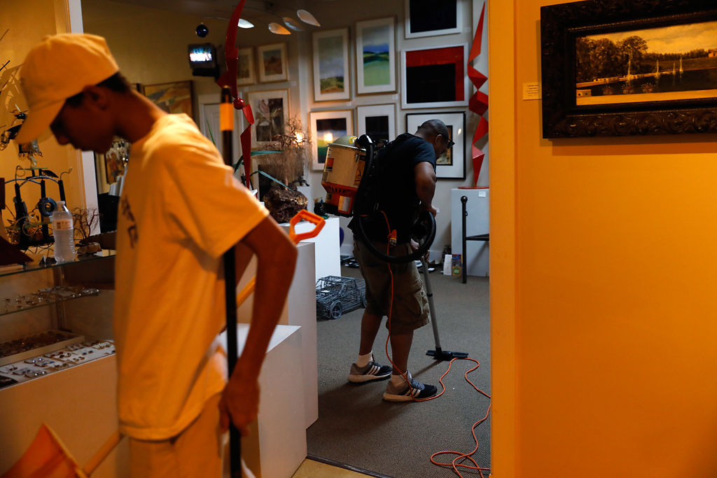 Terrance Smith and his father, Terrance, vacuum broken glass